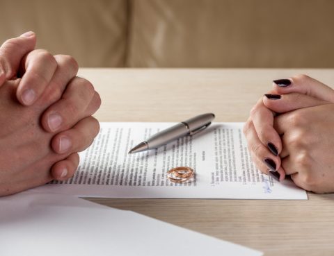 Wife and husband signing divorce documents or premarital agreement