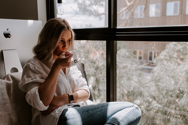 Woman Sipping Hot Drink Inside