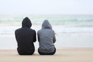 Two People Sitting on a Beach